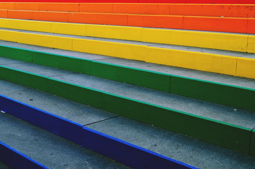 Vibrant rainbow-colored steps create a striking urban art display, perfect for background and design inspiration.