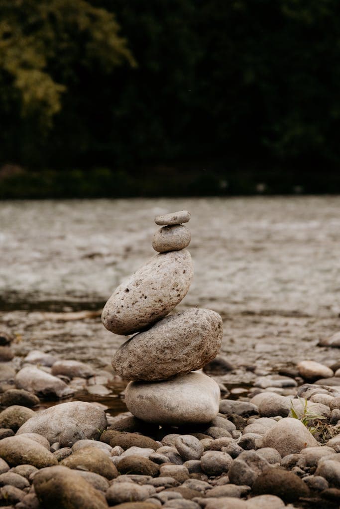 Peaceful riverside scene with stacked stones symbolizing balance and tranquility.